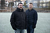 To menn står på en frostdækket fotballbane utendørs.