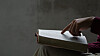 Person leser i en bibel og ber ved et trebord.