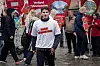 Streikemarkering i Bergen med flere personer, røde plakater og en mann i hvit T-skjorte i forgrunnen.