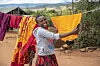 Jente henger klær til tørk på en snor i landsbyen Guje i Tanzania.