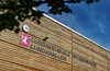 Trebygning med skiltet Lundam skole, kommunevåpen og blå himmel.