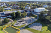 Utsikt over skoleområde med lekeplass, basketbane og boligområde i bakgrunnen.