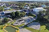 Utsikt over skoleområde med lekeplass, basketbane og boligområde i bakgrunnen.