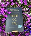 Bok med tittelen «HERR OG FRU» omgitt av lilla og hvite blomster.