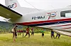 Medevac-fly på gress med flere personer samlet under vingen i Papua Ny-Guinea.