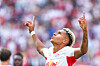 Antonio Nusa feirer en scoring for RB Leipzig med armene løftet foran et uklart publikum.