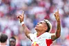 Antonio Nusa feirer en scoring for RB Leipzig med armene løftet foran et uklart publikum.