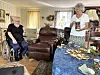 Eldre mann i rullestol og kvinne ved et festdekket bord i en stue