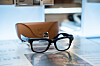 Ray-Ban Meta-smartbriller foran et brunt etui på en utstillingsflate.