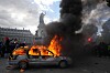 Bil i flammer med kraftig svart røyk under en protest på Republique-plassen i Paris.
