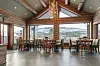 Restaurant med treinnredning, lysekrone og utsikt mot snødekte fjell gjennom store vinduer.