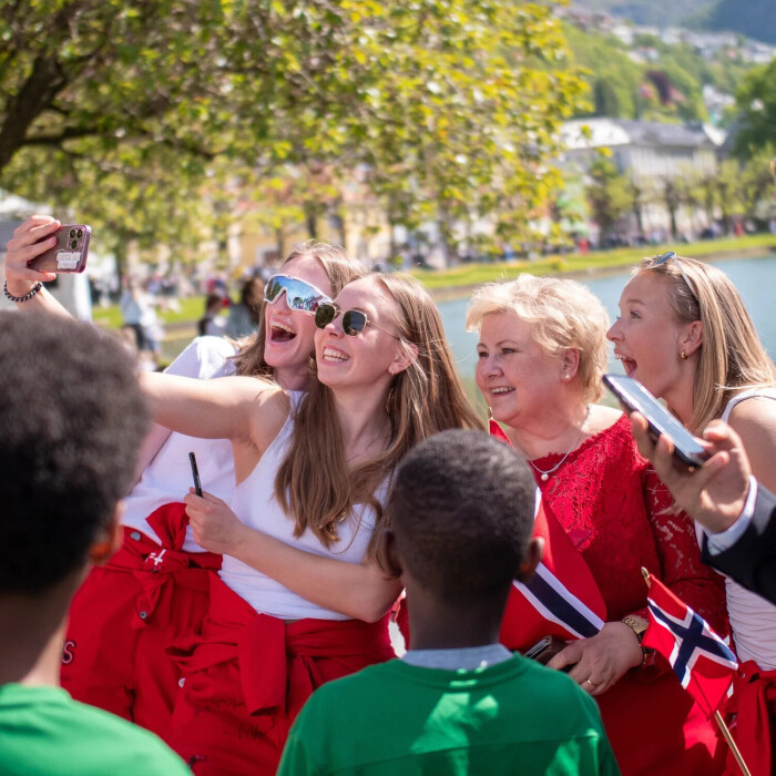 Russ i raudt tek selfie saman med ei eldre dame på 17. mai